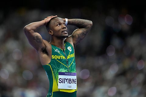 Akani Simbine reacts after crossing the finish line